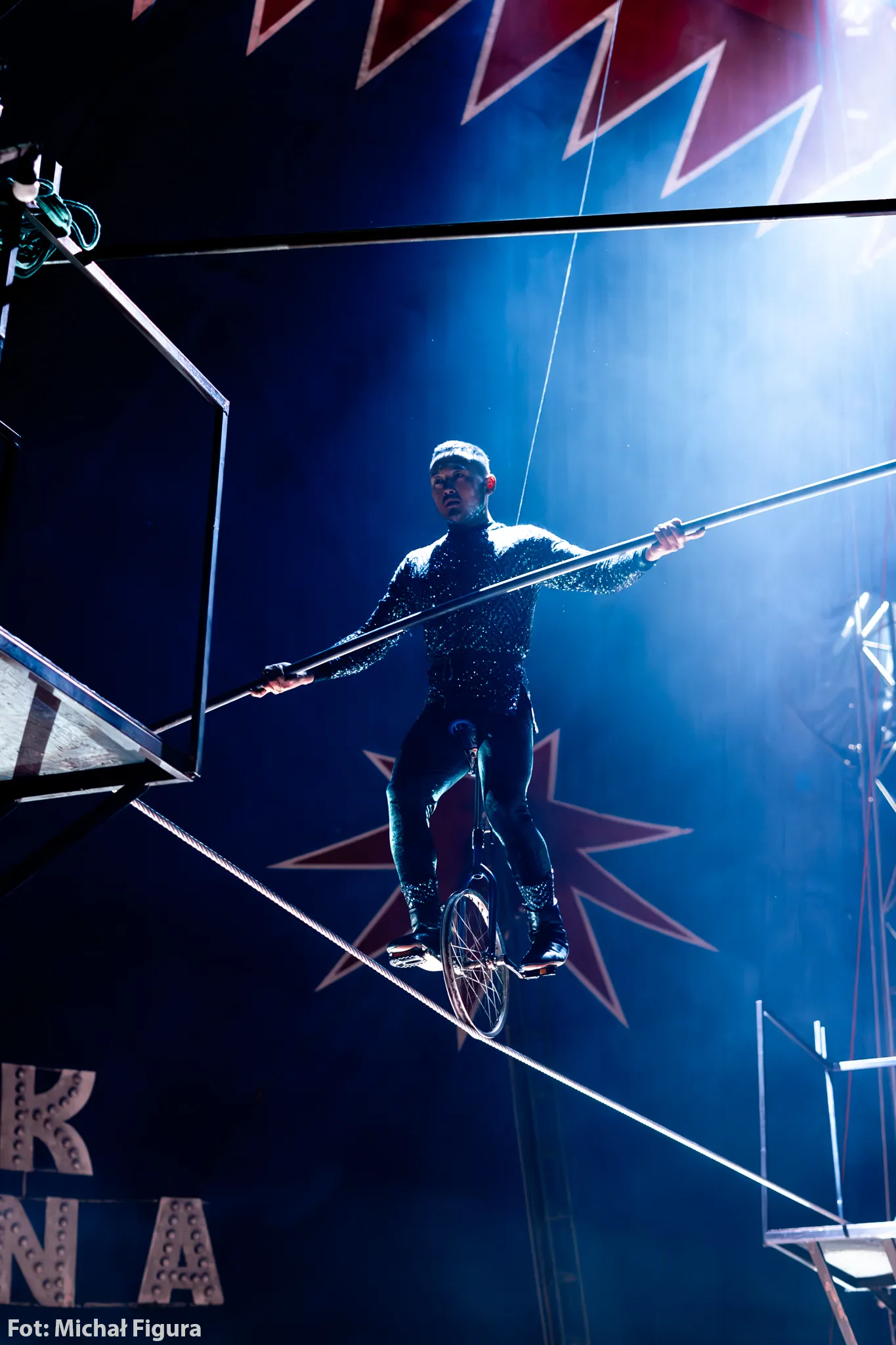 Akrobatka na szarfach zanurzona w teatralnym świetle